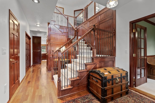 staircase featuring wood finished floors and a towering ceiling