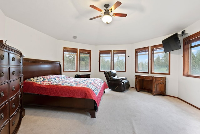 bedroom featuring baseboards, ceiling fan, and light colored carpet