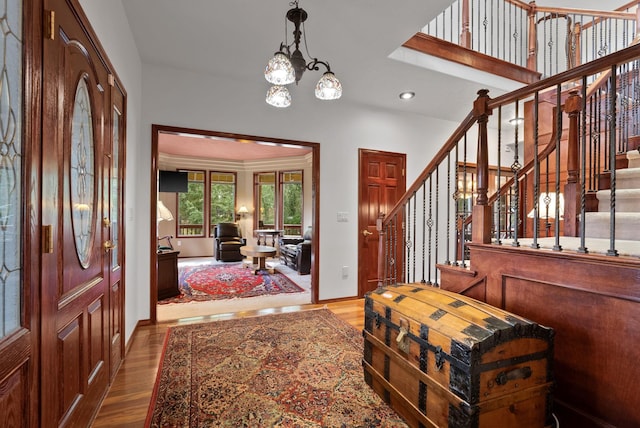 entryway with recessed lighting, a notable chandelier, wood finished floors, baseboards, and stairway