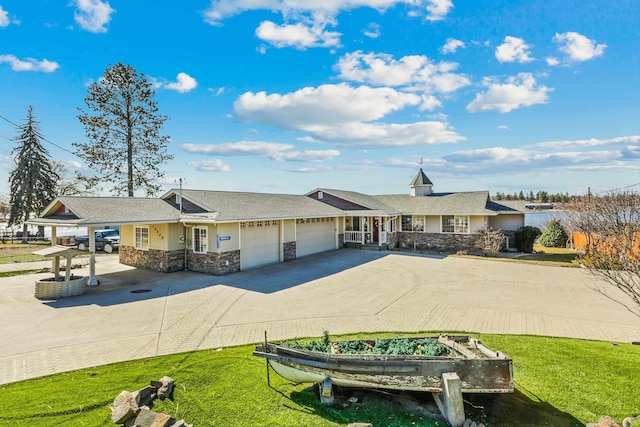 view of front of home with a garage, stone siding, concrete driveway, and a front yard