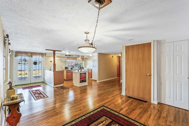 interior space with light wood-style floors, french doors, a textured ceiling, and baseboards