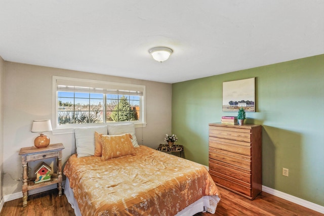 bedroom featuring wood finished floors and baseboards