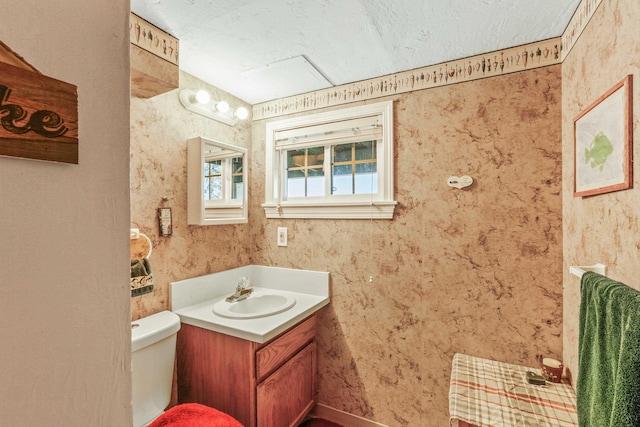 bathroom featuring toilet, a textured ceiling, and vanity