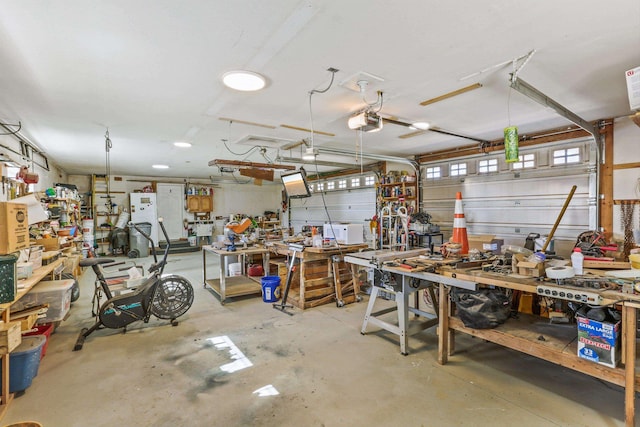 garage with a garage door opener and a workshop area