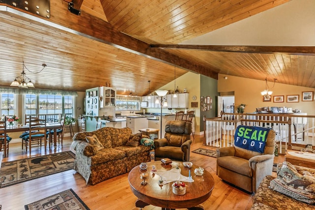 living area with light wood-type flooring, an inviting chandelier, and lofted ceiling with beams