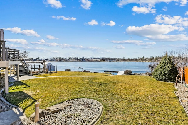 view of yard featuring a water view and stairs