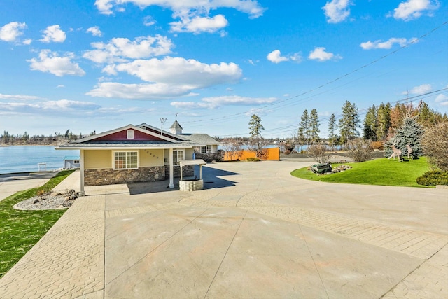 view of front facade with stone siding and a front yard