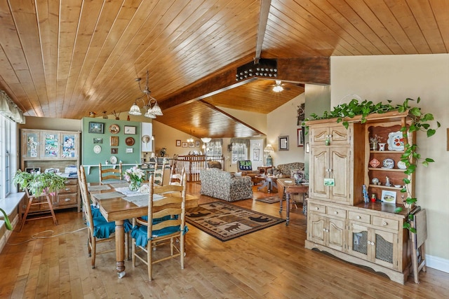 dining space with light wood-type flooring, wooden ceiling, a chandelier, and vaulted ceiling