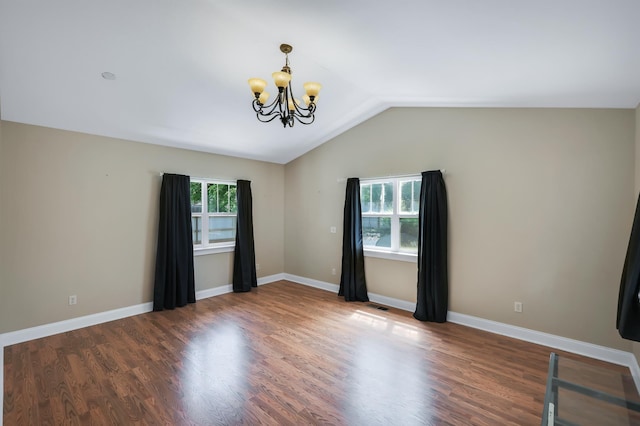 unfurnished room featuring an inviting chandelier, baseboards, vaulted ceiling, and wood finished floors