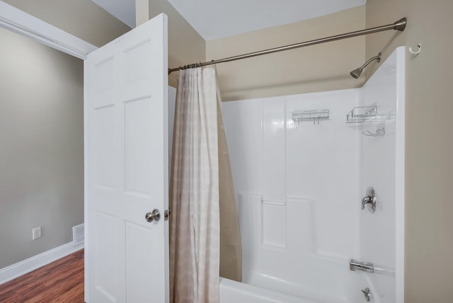 bathroom featuring shower / tub combo, wood finished floors, visible vents, and baseboards