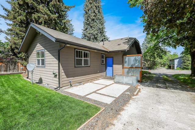 view of front facade with a front yard, a patio area, and fence