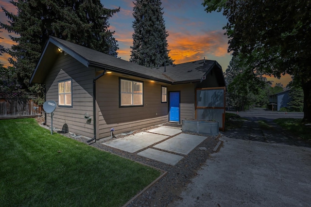 view of front of home featuring a yard, a patio area, and fence