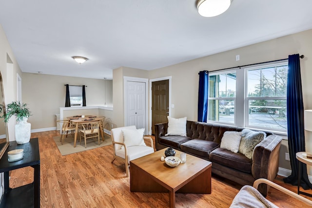 living room featuring light wood-type flooring and baseboards