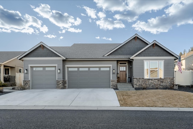 craftsman inspired home featuring stone siding, driveway, an attached garage, and fence