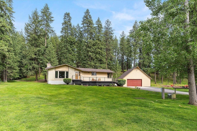 view of front of house with a detached garage, a front lawn, and an outdoor structure