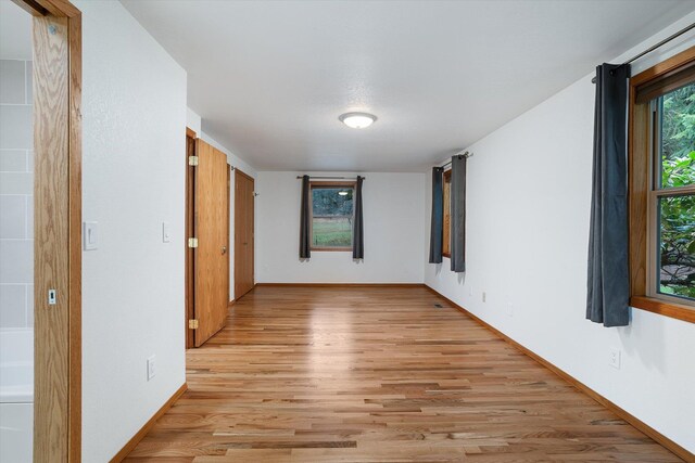 unfurnished room with light wood-style floors and baseboards