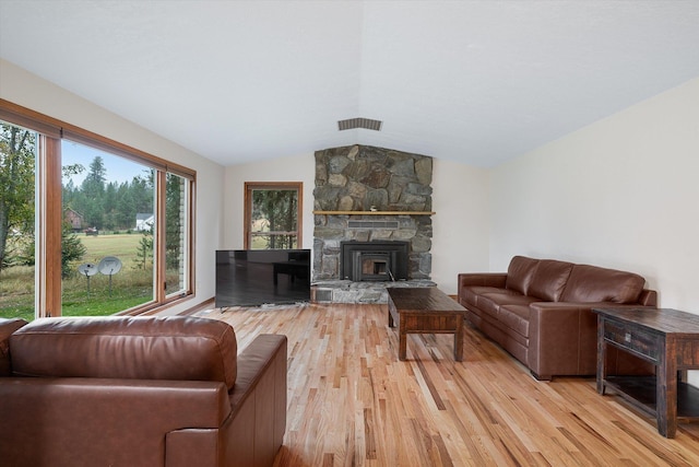 living area with lofted ceiling, visible vents, and light wood finished floors