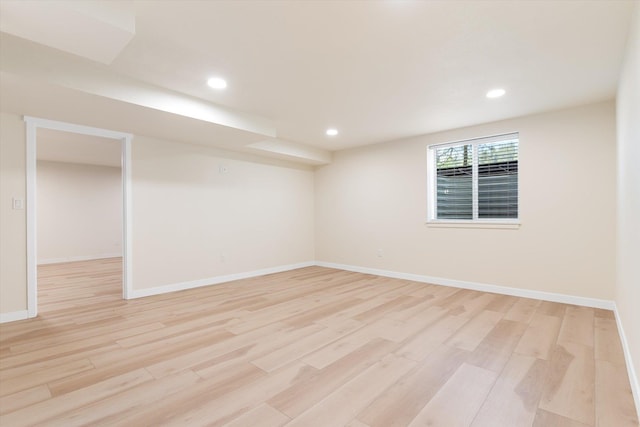 spare room featuring light wood finished floors, baseboards, and recessed lighting