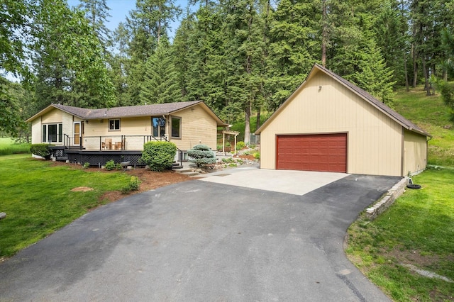 view of front of house featuring a garage, a deck, a front lawn, and an outdoor structure