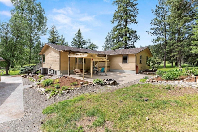 back of property with entry steps, a yard, a patio area, and central air condition unit