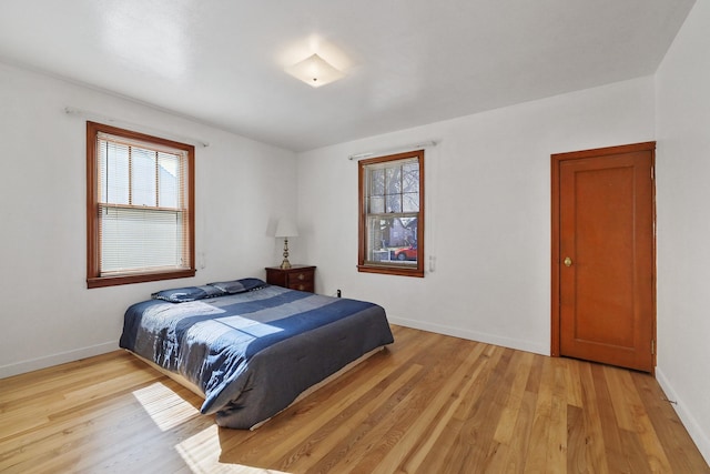 bedroom with light wood-type flooring and baseboards