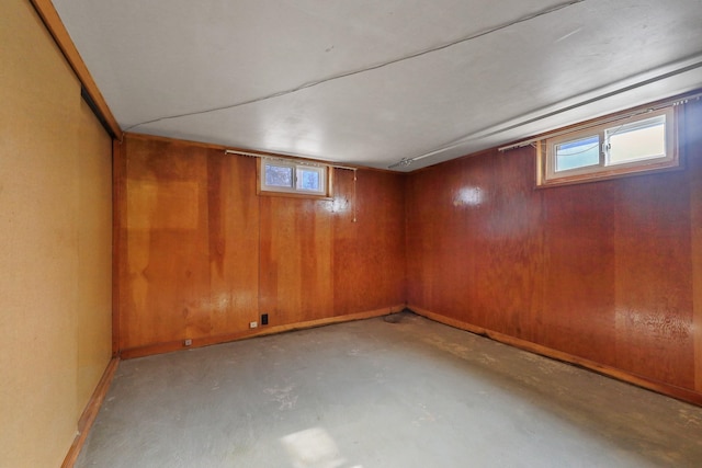 below grade area with wood walls, baseboards, and a wealth of natural light