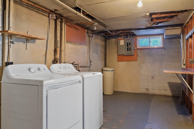 laundry room with laundry area, washing machine and dryer, and electric panel