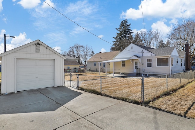 view of front of home with a fenced front yard, an outbuilding, concrete driveway, a gate, and a garage