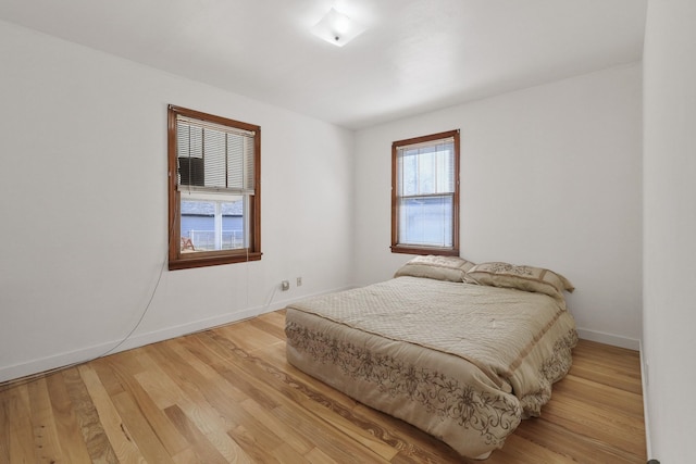 bedroom with light wood-style flooring and baseboards