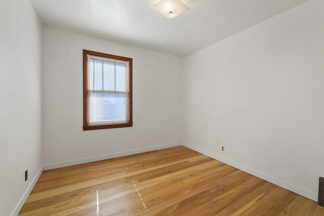 empty room featuring baseboards and light wood-style floors