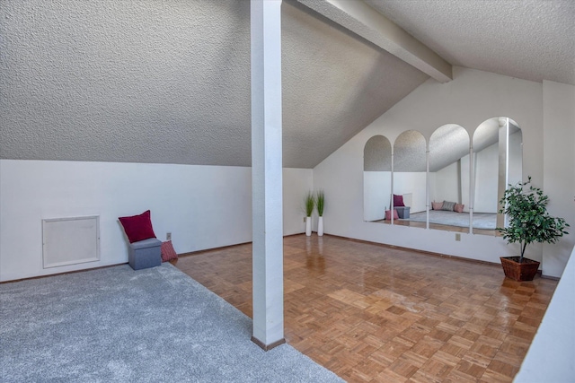 additional living space featuring vaulted ceiling with beams, baseboards, and a textured ceiling