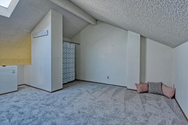 additional living space featuring carpet floors, lofted ceiling with skylight, baseboards, and a textured ceiling