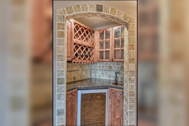 wine cellar featuring a dry bar, beverage cooler, and a sink