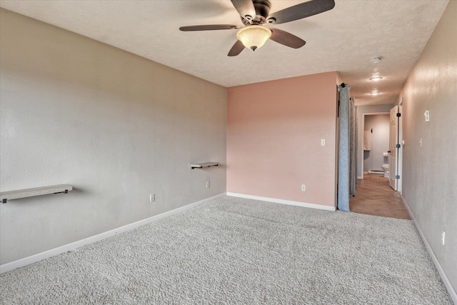 carpeted spare room with baseboard heating, ceiling fan, a textured ceiling, and baseboards