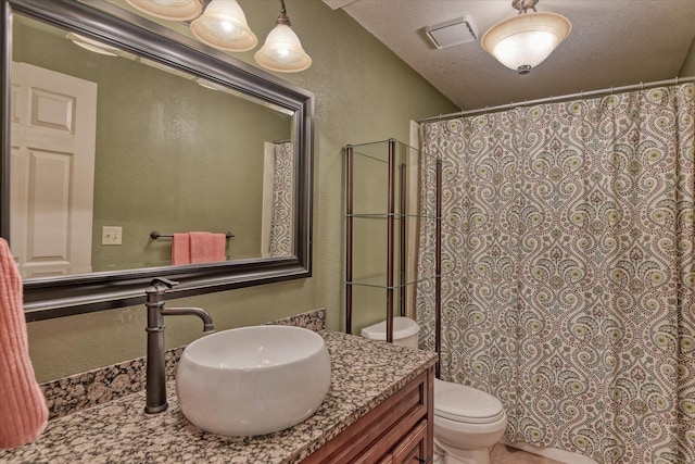 full bath with visible vents, a textured wall, toilet, a textured ceiling, and vanity