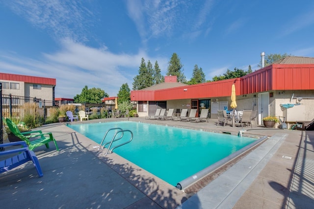 pool with a patio and fence