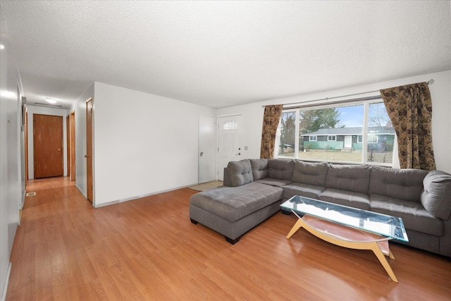 living area with light wood-style floors and a textured ceiling