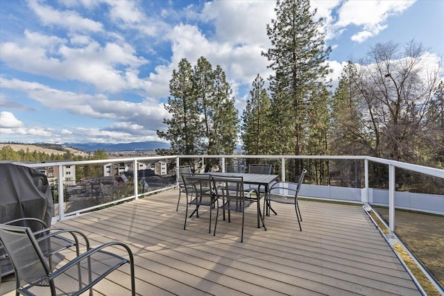 wooden terrace featuring outdoor dining space and a mountain view