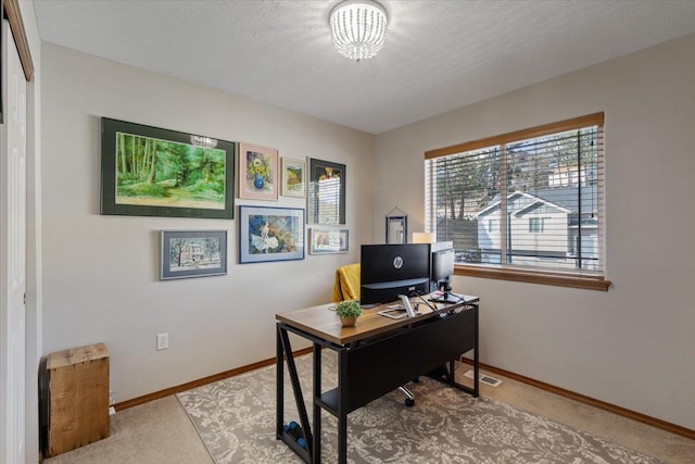 carpeted home office with visible vents, baseboards, and a textured ceiling