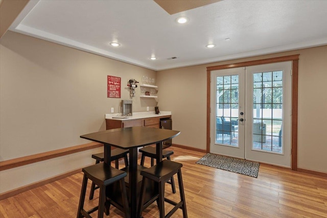 dining space featuring recessed lighting, french doors, light wood-style flooring, and baseboards