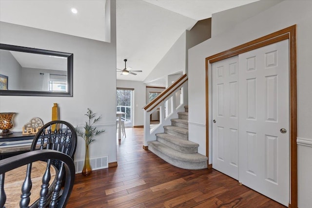 entrance foyer featuring baseboards, visible vents, stairway, wood finished floors, and vaulted ceiling