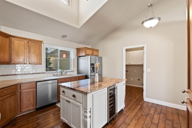 kitchen with beverage cooler, appliances with stainless steel finishes, dark wood-type flooring, and a sink