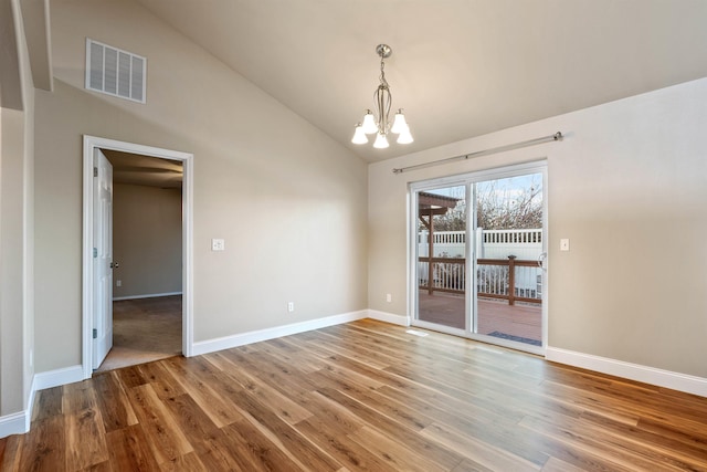 interior space with a notable chandelier, visible vents, wood finished floors, high vaulted ceiling, and baseboards