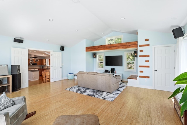 living room with high vaulted ceiling, baseboards, and wood finished floors