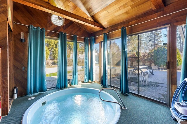 sunroom / solarium with a healthy amount of sunlight, wooden ceiling, a hot tub, and lofted ceiling