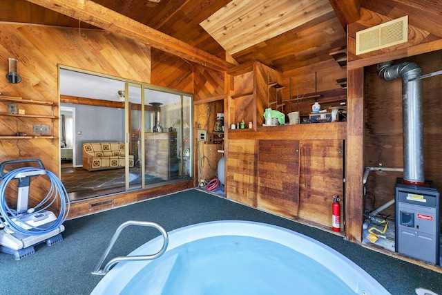 interior space with wood ceiling, visible vents, vaulted ceiling, and wooden walls