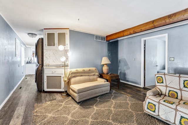 living area with baseboards, visible vents, and wood finished floors