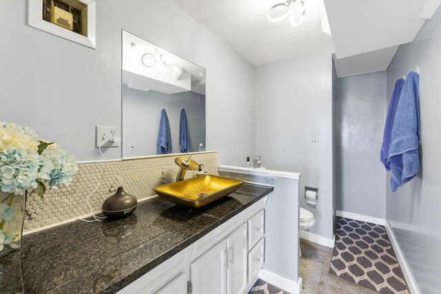 6514 N Sutherlin St, Spokane, WA 99208 - bathroom with vanity, backsplash, toilet, baseboards, and wood finished floors