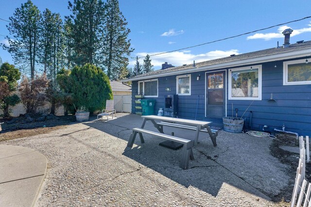 rear view of property with a patio, a chimney, and fence