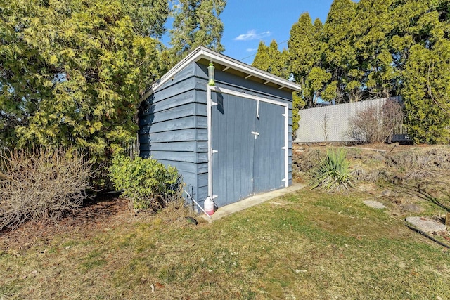 view of shed featuring fence